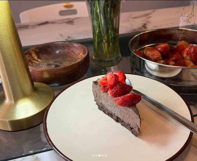 A slice of chocolate cheesecake with a strawberry on top